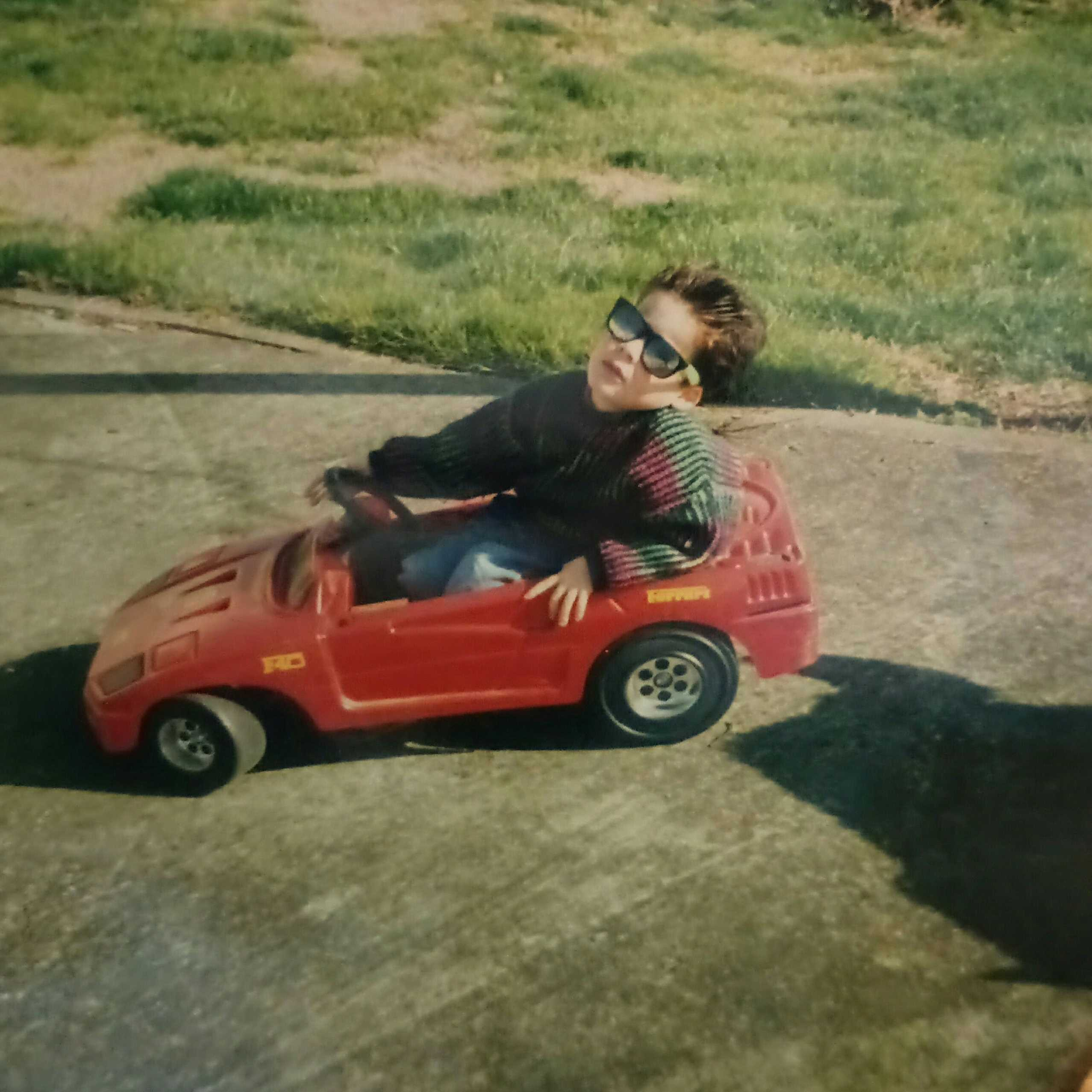 Daniel as a child in a pedal car
